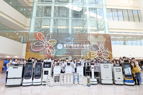 지난 17일 용인세브란스병원 1층 로비에서 개최된 의료서비스로봇 소개 행사에 참여한 교직원이 6종 11대의 의료서비스로봇과 함께 단체사진을 찍고 있다.